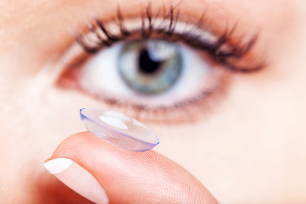 Woman eye with contact lens applying