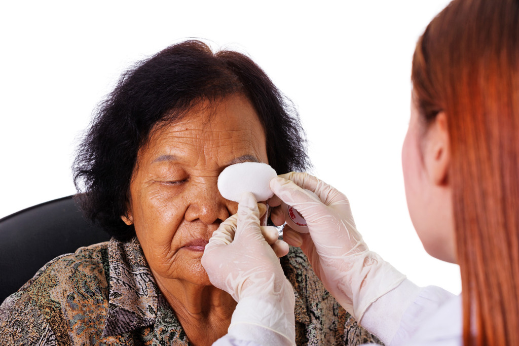 doctor bandaging patient's eye